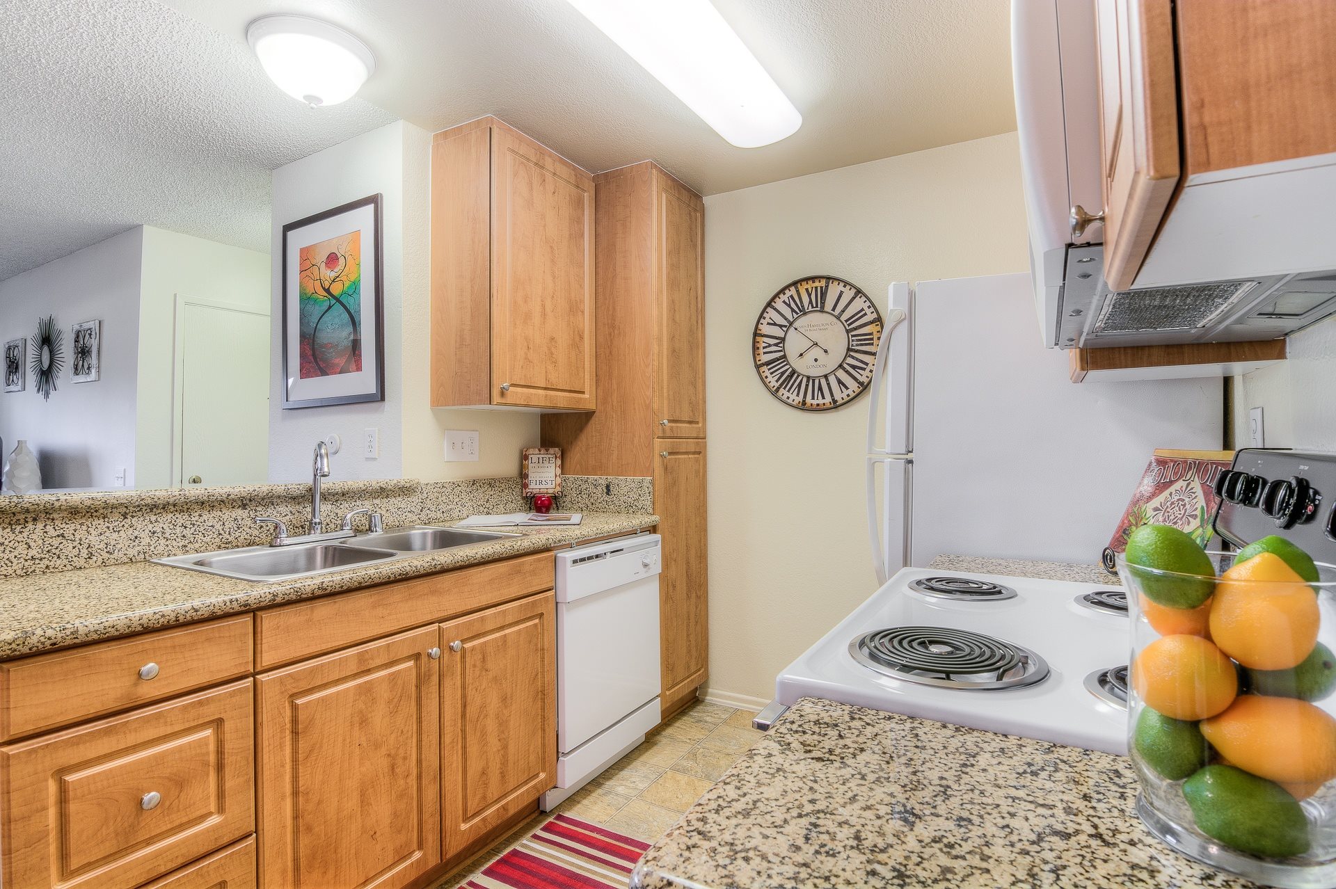 A kitchen with wooden cabinets and a white stove top oven.,A kitchen with wooden cabinets and a white stove top oven.